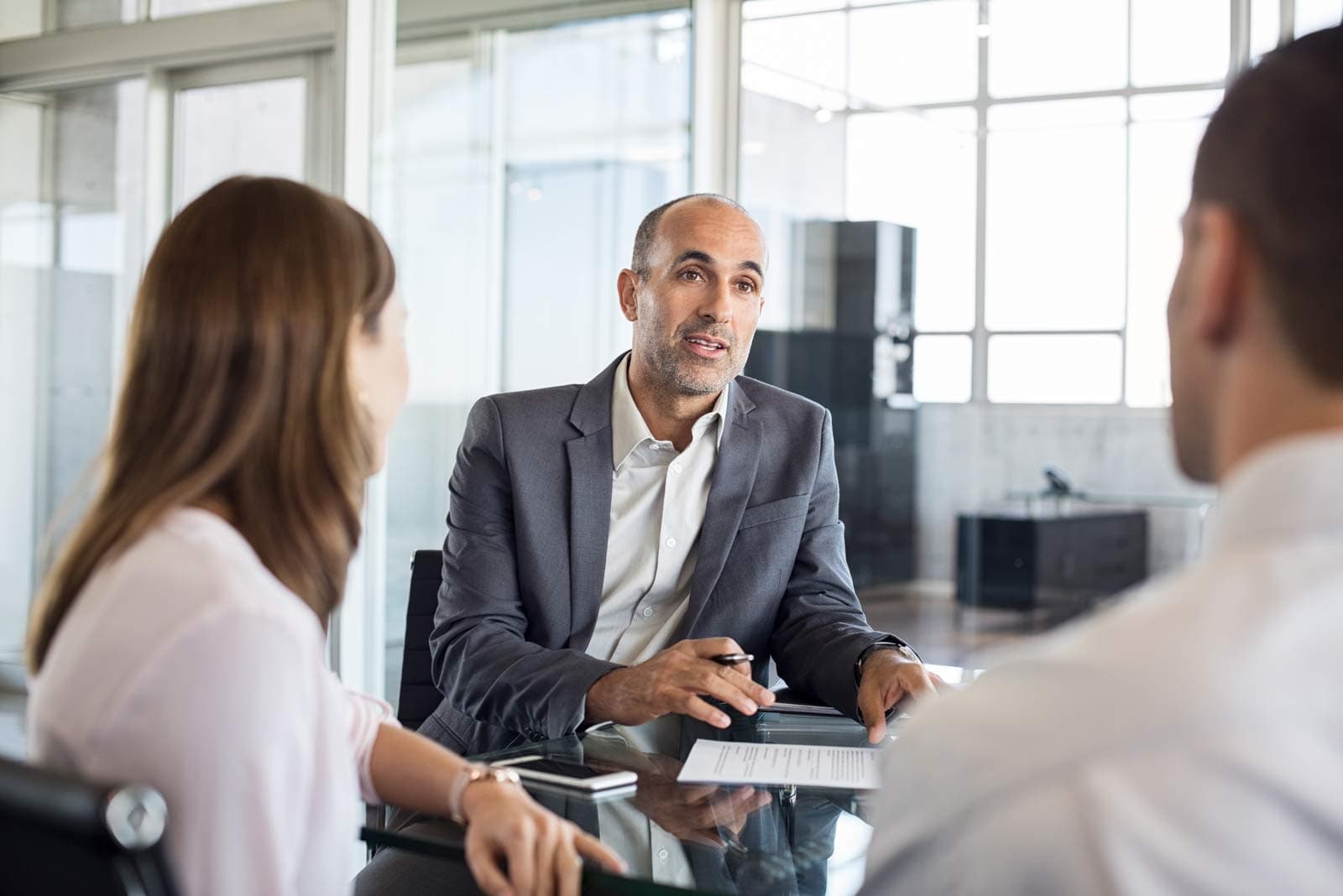 A woman sitting with a financial advisor reviewing documents at a table